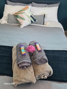 a bed with two towels and flowers on it at Sandy Toes Airbnb in Glengariff