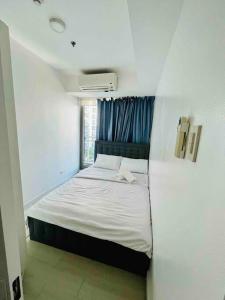 een slaapkamer met een bed met een blauw gordijn bij Positano 2br Beach View in Manilla