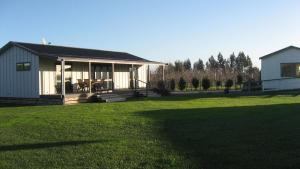 a home with a large yard with a house at Bluebell Lodge and Cottage in Havelock North