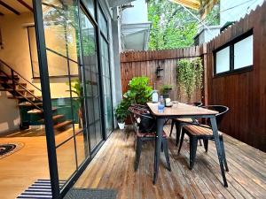 un patio avec une table et des chaises sur une terrasse dans l'établissement Shanghai Hills & ZINN City Bnb Near Line13 Mid Huaihai Rd & Changle Rd, à Shanghai