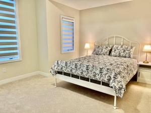 ein Schlafzimmer mit einem Bett, zwei Lampen und einem Fenster in der Unterkunft Spacious 4BR Home near Hamilton Airport in Caledonia