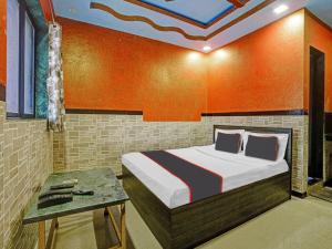 a bedroom with a bed and a table at Collection O Kinny Farmhouse And Resort in Dāndepāda
