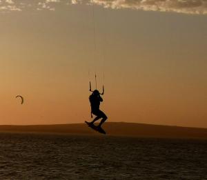 a man kiteboarding over the water at sunset at Studio On Fairway in Langebaan