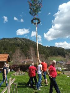 a group of men are holding up a tall tree at Ferienwohnung Eduard in Mühlen