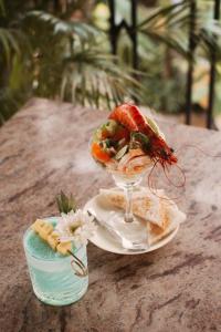 a table with a plate of food and a wine glass at Fiesta Beach Resort in Baga