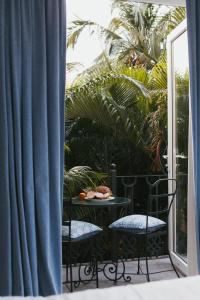 un balcone con 2 sedie e un tavolo con un piatto di cibo di Fiesta Beach Resort a Baga
