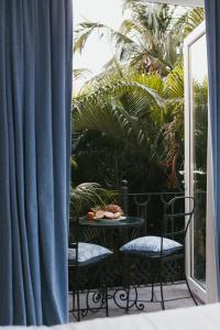 a balcony with two chairs and a table with a plate of food at Fiesta Beach Resort in Baga