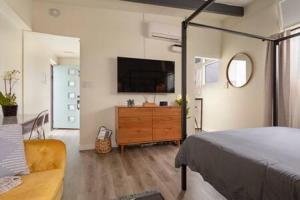 1 dormitorio con 1 cama y vestidor con TV en STAY NEXT TO THE SAND Best Hermosa Pier Location en Hermosa Beach