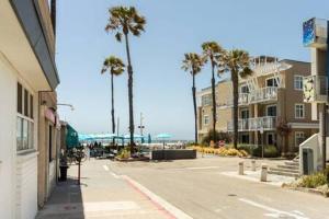 una calle de la ciudad con palmeras y un edificio en STAY NEXT TO THE SAND Best Hermosa Pier Location en Hermosa Beach