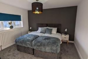 a bedroom with a large bed and a chandelier at Gilliver House in Newbold Verdon