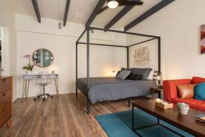 - une chambre avec un lit à baldaquin et un canapé dans l'établissement Stylish Hermosa Pier Getaway plus free parking, à Hermosa Beach