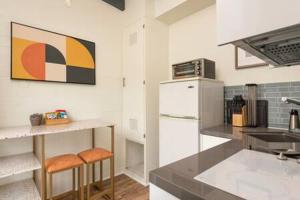 a kitchen with a sink and a counter with stools at Stylish Hermosa Pier Getaway plus free parking in Hermosa Beach