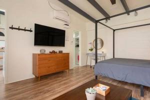 a bedroom with a bed and a tv on a wall at Stylish Hermosa Pier Getaway plus free parking in Hermosa Beach