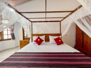 マータラにあるDill Villa Matara Walpola - Cozy 3bedroom 2Bathroom -Entire Floorのベッドルーム1室(天蓋付きベッド1台、赤い枕付)