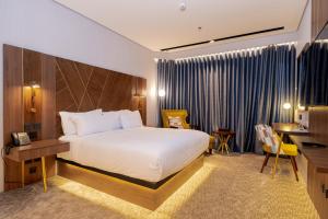 ein Hotelzimmer mit einem Bett und einem Schreibtisch in der Unterkunft Damask Hotels in Al Hada
