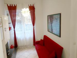 格羅塔姆馬雷的住宿－Grottammare mon amour Kira，窗户房间里一张红色的沙发