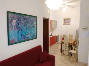格羅塔姆馬雷的住宿－Grottammare mon amour Kira，客厅配有红色的沙发和墙上的绘画