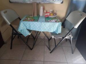 a table with two chairs and a blue table cloth on it at The best place to rest near Tocumen Airport in Panama City