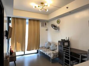 - un salon avec un canapé et une fenêtre dans l'établissement A Home with a view, 1 Bdrm with balcony and Netflix Access, à Manille