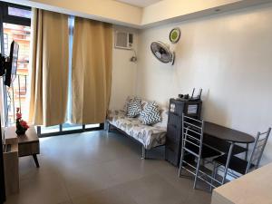un soggiorno con divano e tavolo di A Home with a view, 1 Bdrm with balcony and Netflix Access a Manila