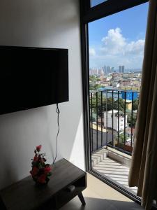 Cette chambre dispose d'une grande fenêtre offrant une vue sur la ville. dans l'établissement A Home with a view, 1 Bdrm with balcony and Netflix Access, à Manille