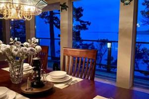 un comedor con una mesa con platos y flores en SaliHaven: Oceanfront 4Bedrooms 5Beds 3 5Bath, en Bedwell Harbour