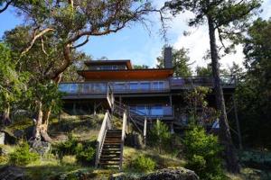 a house sitting on top of a hill with trees at SaliHaven: Oceanfront 4Bedrooms 5Beds 3 5Bath in Bedwell Harbour