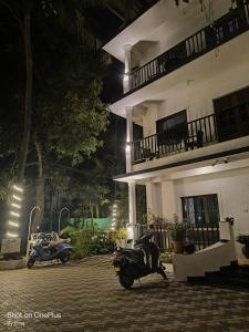 a motorcycle parked in front of a building at night at Sabinas Goa in Saligao