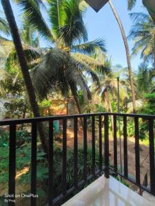 a view from the balcony of a resort with palm trees at Sabinas Goa in Saligao