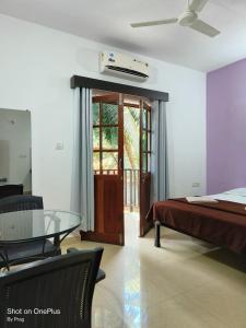 a bedroom with a bed and a glass table at Sabinas Goa in Saligao
