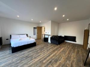 a bedroom with a bed and a desk and a couch at Modern Studio Apartment Near Glenfield Hospital in Glenfield