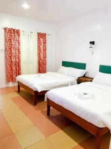 una camera con due letti e una finestra con tende di Kakisa ll Diving Resort a Bacong