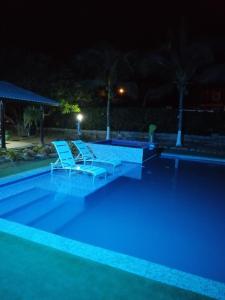 - une piscine avec 2 chaises longues la nuit dans l'établissement Espectacular Cabaña en Santa Veronica, à Santa Veronica