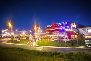 a large building with neon signs at night at Delux apartment LA ARENA with private garage in Zagreb