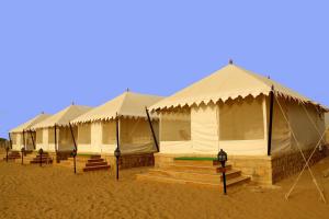 a row of luxury tents in the desert at Ozaki Desert Camp in Jaisalmer