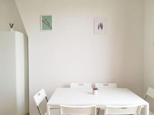 ein weißes Esszimmer mit einem weißen Tisch und Stühlen in der Unterkunft Lovely three-room apartment near metro station in Saint-Denis