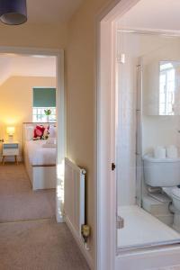 a bathroom with a bedroom with a bed and a sink at Chaveney Cottage in Quorndon
