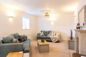 a living room with two couches and a tv at Chaveney Cottage in Quorndon