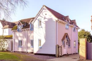 a white house with blue windows on a street at Chaveney Cottage in Quorndon