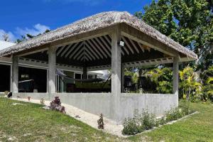 a pavilion with a grass roof on a lawn at The Cove Vanuatu in Port Vila