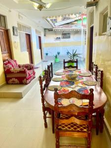 a dining room with a table with chairs and a couch at Mystic Manor Stonetown B&B in Stone Town