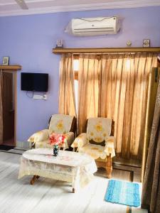 a living room with two chairs and a table at Bikaner bliss - guest suite in Bikaner