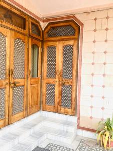 - une entrée pour une maison avec une porte en bois dans l'établissement Bikaner bliss - guest suite, à Bikaner