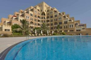 a large apartment building with a large swimming pool at Luxury, One bedroom apartment Ocean view in Ras al Khaimah