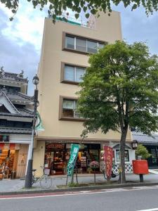 um edifício alto com uma árvore em frente em Guest houseTakagi - Vacation STAY 59918v em Matsumoto