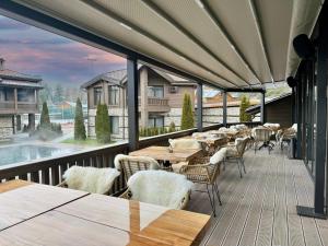 a patio with tables and chairs on a deck at V Chalet Residence in Velingrad