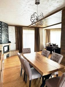 uma sala de jantar com uma mesa de madeira e cadeiras em V Chalet Residence em Velingrad