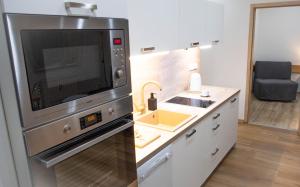 a kitchen with a microwave and a sink at Špičák 77 Prokop STARt point No 105B in Železná Ruda