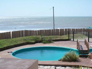 هوستيريا لوس ترونكوس في سانتا كلارا ديل مار: حمام سباحة صغير مع المحيط في الخلفية