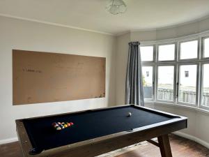 a room with a pool table and a chalkboard at Oamaru Villa in Oamaru